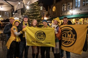 Glimt-supportere poserer med Glimt-flagg på torget i Brugge foran kampen mot Club Brugge i desember 2023